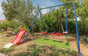 un parco giochi con quattro altalene in un cortile di Amazing Home In Lozovac With Kitchen a Lozovac