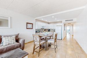 a living room with a table and chairs and a kitchen at Fairways #204 in Padre Island