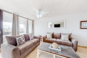 a living room with two couches and a table at Fairways #204 in Padre Island