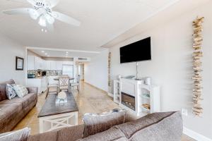 a living room with a couch and a flat screen tv at Fairways #204 in Padre Island