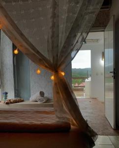 a bedroom with a bed with a canopy and a window at Estaleiro Casa Hotel in Balneário Camboriú