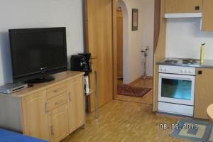 a kitchen with a flat screen tv on a stand with a stove at Ers Curtins in Zernez