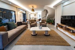a living room with a couch and a table at merkezde 8 kişilik özel havuzlu villa in Fethiye