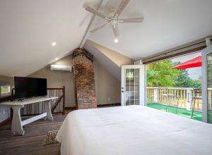 een slaapkamer met een groot bed en een televisie bij 1786 Farm Cottage Honeymoon Suite Renovated 2022 in Chester