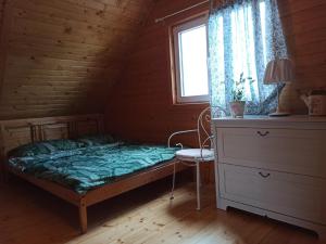 a bedroom with a bed and a window and a dresser at Słoneczne Tarasy in Sasino