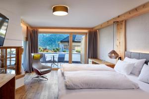 a bedroom with a bed and a desk and a chair at Hotel Tirol Fiss in Fiss