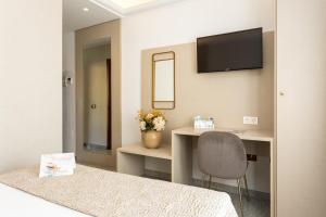 Pokój z biurkiem i telewizorem na ścianie w obiekcie Hotel Plaza Del Castillo w Maladze