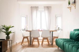 een woonkamer met een tafel en stoelen en een bank bij DWELLSTAY - Wohnung 90qm, 3 Schlafzimmer, Küche, Wohnzimmer, Balkon, Netflix in Fulda