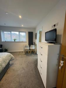 a bedroom with a tv on top of a dresser at Abbey’s Inn in Cheadle