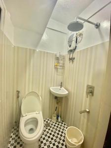 a small bathroom with a toilet and a sink at Tiny Room Hura Homes II Condominium Unit Visayas Avenue QC in Manila