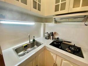 a small kitchen with a sink and a stove at Tiny Room Hura Homes II Condominium Unit Visayas Avenue QC in Manila