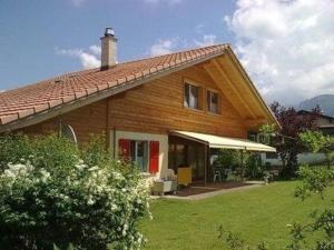 una gran casa de madera con un patio verde en Sunneggli en Aeschi bei Spiez