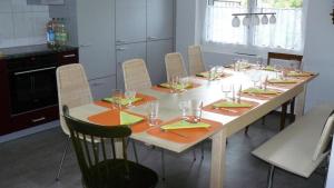 a dining room table with chairs and a large table with glasses at Sunneggli in Aeschi bei Spiez