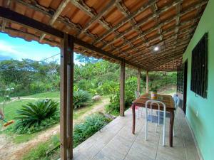 eine Terrasse mit einem Holztisch und Stühlen darauf in der Unterkunft Casa no Sítio in Guaramiranga