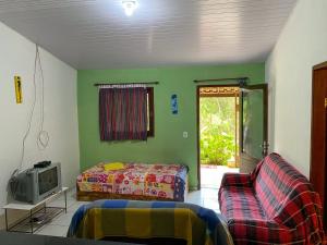 een woonkamer met een bank, een bed en een tv bij Casa no Sítio in Guaramiranga