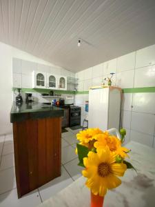 eine Küche mit einer Vase mit gelben Blumen darin in der Unterkunft Casa no Sítio in Guaramiranga