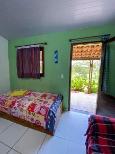 een slaapkamer met een bed en een raam bij Casa no Sítio in Guaramiranga