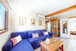 a blue couch in a living room with a table at Swift Beach House in Wareham