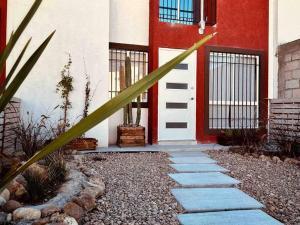 a house with a red and white door and a plant at casa buu in San Miguel de Allende