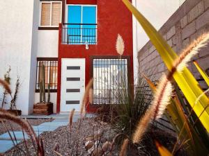 a red and white house with a white door and window at casa buu in San Miguel de Allende