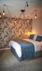 um quarto com uma cama grande e papel de parede floral em Home @ 2 Tancred Road em Liverpool