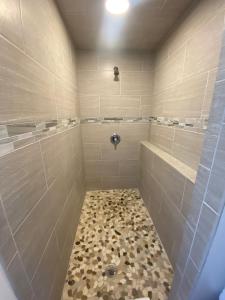 a large bathroom with a shower with a drain at City Center Motel in Missoula