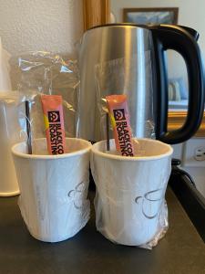 two white bowls sitting on a counter with a tea kettle at City Center Motel in Missoula