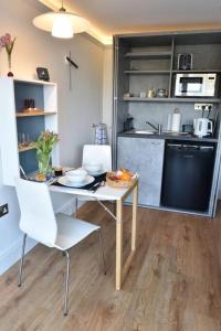 uma cozinha com mesa e cadeiras num quarto em The Annexe em Shaldon