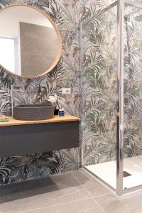 ein Badezimmer mit einem Waschbecken und einem Spiegel an der Wand in der Unterkunft Civicocento Charming Rooms in Catania