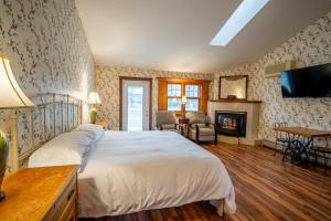 a bedroom with a large bed and a fireplace at Albergo Allegria Hotel & Breakfast Restaurant in Windham
