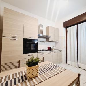 a kitchen with white cabinets and a table with a potted plant at San Siro House in Milan