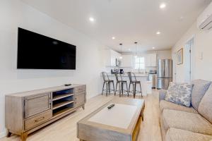 a living room with a couch and a tv on a wall at Rehoboth Beach House --- 20494 Coastal Highway Unit #1 in Rehoboth Beach