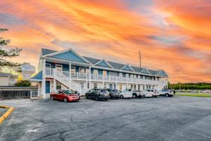 a large building with cars parked in a parking lot at Rehoboth Beach House --- 20494 Coastal Highway Unit #1 in Rehoboth Beach