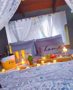 Una cama con velas y una bandeja de comida. en Estaleiro Casa Hotel, en Balneário Camboriú