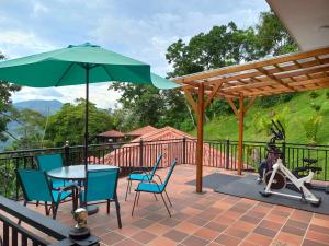 une terrasse avec une table, des chaises et un parasol dans l'établissement hotel villa paz d f, à La Vega