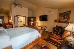 um quarto com uma cama grande e um sofá em Albergo Allegria Hotel & Breakfast Restaurant em Windham