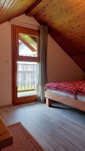 a attic room with a bed and a window at Ferienhaus auf dem Werteshof in Peißenberg