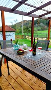 una mesa de madera con 2 copas de vino en una terraza en Ferienhaus auf dem Werteshof, en Peißenberg