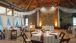 a banquet hall with tables and chairs with white drapes at POSTOAK Lodge and Retreat in Tulsa