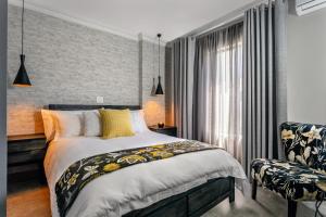 a bedroom with a bed and a chair at Woman Era Guest House in Midrand
