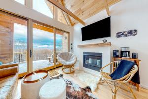 a living room with a fireplace and a tv at The Alpine Outlook in Londonderry