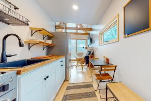 a kitchen with white cabinets and a sink and a table at The Alpine Outlook in Londonderry
