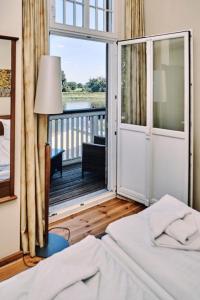 1 dormitorio con 1 cama y balcón con vistas. en Elbterrasse Wörlitz, en Oranienbaum-Wörlitz