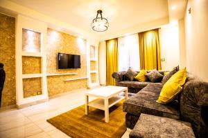 uma sala de estar com um sofá e uma televisão em Yellow & brown moderne style Near food-court no Cairo