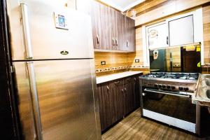 uma cozinha com um frigorífico de aço inoxidável e um fogão em Yellow & brown moderne style Near food-court no Cairo