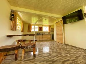 cocina con mesa y sillas y TV de pantalla plana. en Cabaña campestre en Chiquinquirá, en Saboyá