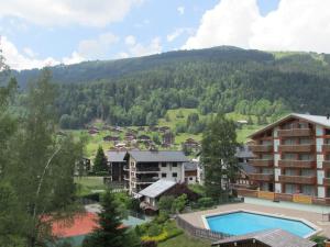 ein Resort mit einem Pool und einem Berg in der Unterkunft Appartement Les Gets, 2 pièces, 6 personnes - FR-1-623-167 in Les Gets