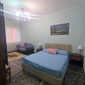 a bedroom with a blue bed and a couch at Appartamento Bergamo in Laigueglia