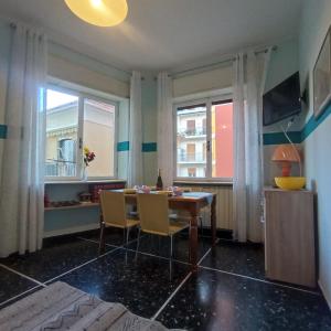 una sala da pranzo con un tavolo e due finestre di Appartamento Bergamo a Laigueglia