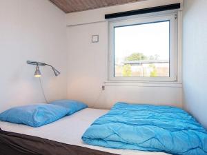 - un lit avec des draps bleus dans une chambre avec une fenêtre dans l'établissement Comfortable Holiday Home in B rkop with Terrace, à Børkop
